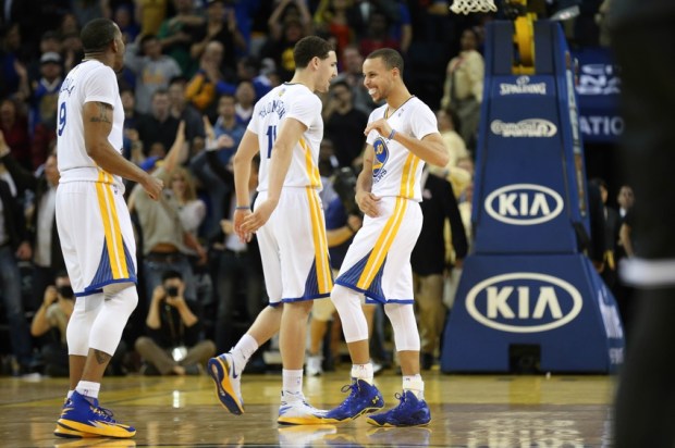 Feb 22, 2014; Oakland, CA, USA; Golden State Warriors point guard Stephen Curry (30) celebrates with shooting guard Klay Thompson (11) and small forward Andre Iguodala (9) after scoring a three point basket against the Brooklyn Nets during the fourth quarter at Oracle Arena. The Golden State Warriors defeated the Brooklyn Nets 93-86. Mandatory Credit: Kelley L Cox-USA TODAY Sports