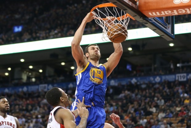 Mar 2, 2014; Toronto, Ontario, CAN; Golden State Warriors center Andrew Bogut (12) dunks against the Toronto Raptors at Air Canada Centre. The Raptors beat the Warriors 104-98. Mandatory Credit: Tom Szczerbowski-USA TODAY Sports