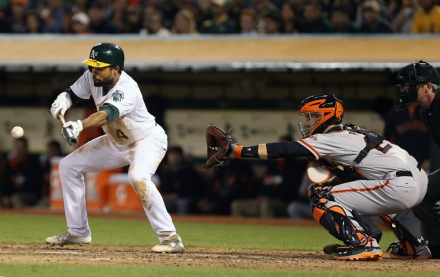 Jul 7, 2014; Oakland, CA, USA; Oakland Athletics center fielder Coco Crisp (4) reaches on a bunt single against the San Francisco Giants during the fifth inning at O.co Coliseum. Mandatory Credit: Kelley L Cox-USA TODAY Sports