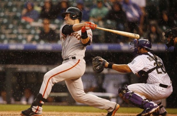 May 22, 2014; Denver, CO, USA; San Francisco Giants catcher Buster Posey (28) hits a single during the fifth inning against the Colorado Rockies at Coors Field. Mandatory Credit: Chris Humphreys-USA TODAY Sports