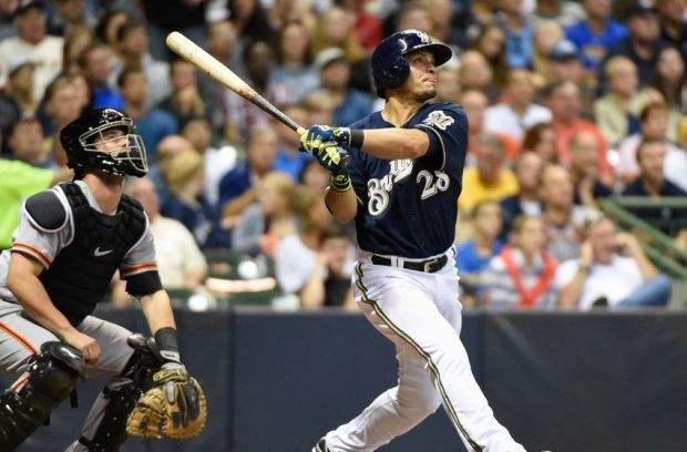 Aug 5, 2014; Milwaukee, WI, USA; Milwaukee Brewers right fielder Gerardo Parra (28) hits a solo home run in the seventh inning as San Francisco Giants catcher Andrew Susac (34) watches at Miller Park. Mandatory Credit: Benny Sieu-USA TODAY Sports