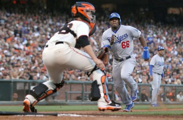 Jul 26, 2014; San Francisco, CA, USA;  Los Angeles Dodgers center fielder Yasiel Puig (66) scores in front of San Francisco Giants catcher Buster Posey (28) in the sixth inning at AT&T Park. Mandatory Credit: Lance Iversen-USA TODAY Sports