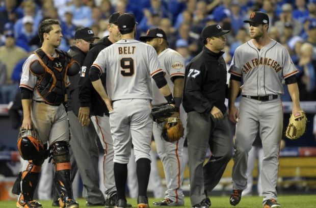 Oct 22, 2014; Kansas City, MO, USA; San Francisco Giants relief pitcher Hunter Strickland (right) is escorted away from home plate by umpire Jim Reynolds (77) in the sixth inning against the Kansas City Royals during game two of the 2014 World Series at Kauffman Stadium. Mandatory Credit: Christopher Hanewinckel-USA TODAY Sports