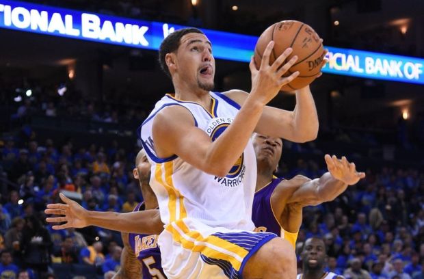 November 1, 2014; Oakland, CA, USA; Golden State Warriors guard Klay Thompson (11, center) drives to the basket against Los Angeles Lakers forward Carlos Boozer (5) and forward Wesley Johnson (11, right) during the third quarter at Oracle Arena. The Warriors defeated the Lakers 127-104. Mandatory Credit: Kyle Terada-USA TODAY Sports