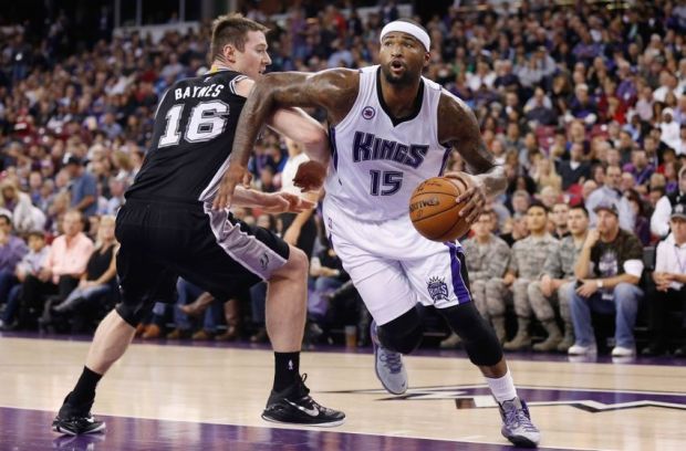 Nov 15, 2014; Sacramento, CA, USA; Sacramento Kings center DeMarcus Cousins (15) drives against San Antonio Spurs forward Aron Baynes (16) during the first quarter at Sleep Train Arena. Mandatory Credit: Kelley L Cox-USA TODAY Sports