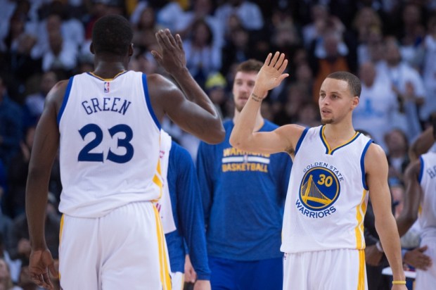 January 5, 2015; Oakland, CA, USA; Golden State Warriors guard Stephen Curry (30) celebrates with forward Draymond Green (23) during the third quarter against the Oklahoma City Thunder at Oracle Arena. The Warriors defeated the Thunder 117-91. Mandatory Credit: Kyle Terada-USA TODAY Sports