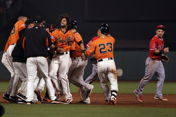 May 1, 2015; San Francisco, CA, USA; Los Angeles Angels second baseman Johnny Giavotella (12) looks on as San Francisco Giants celebrate a walk-off base hit by Giants second baseman Joe Panik (12) that scored pinch runner Gregor Blanco (7) in the ninth inning of their MLB baseball game at AT&T Park. Mandatory Credit: Lance Iversen-USA TODAY Sports. Giants won 3-2.